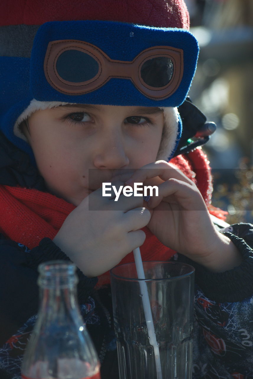 PORTRAIT OF BOY DRINKING WATER AT CAMERA