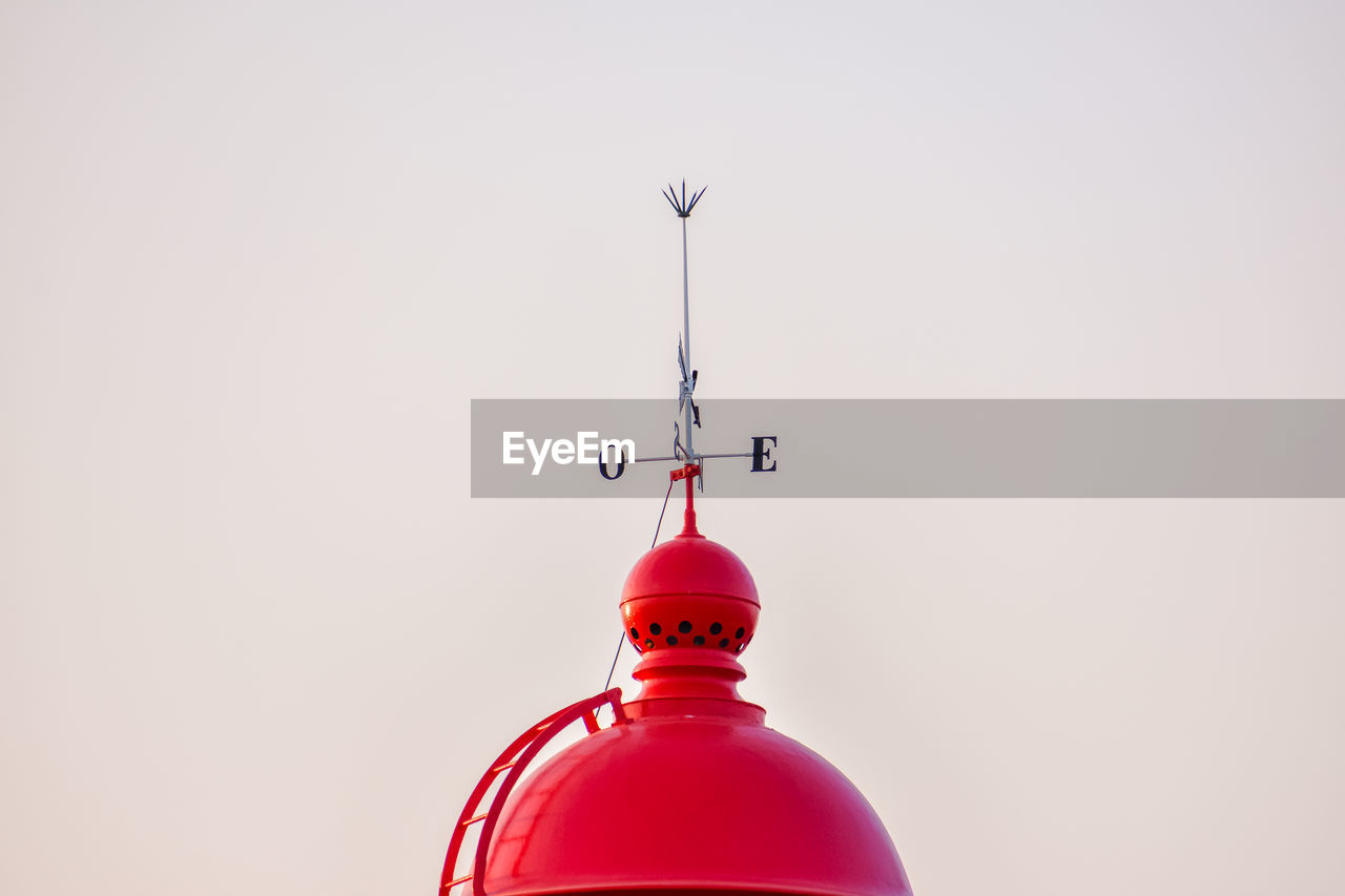 Red dome of the ponta da piedade lighthouse, with a wind vane on top. algarve, portugal