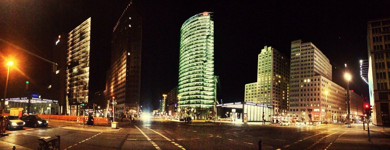 Low angle view of buildings and illuminated street at potsdamer platz