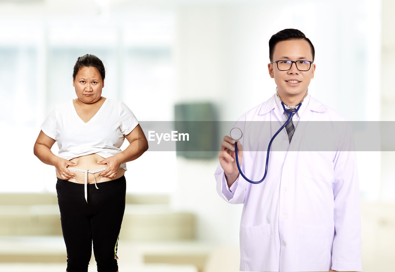 Portrait of male doctor with overweight female patient in hospital