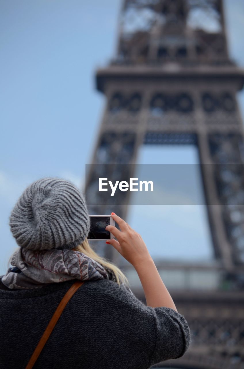 Woman photographing eiffel tower