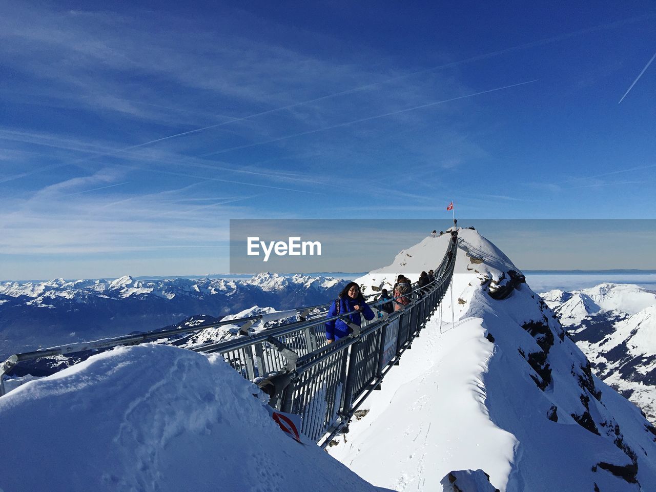 PEOPLE ON SNOW COVERED MOUNTAIN AGAINST SKY