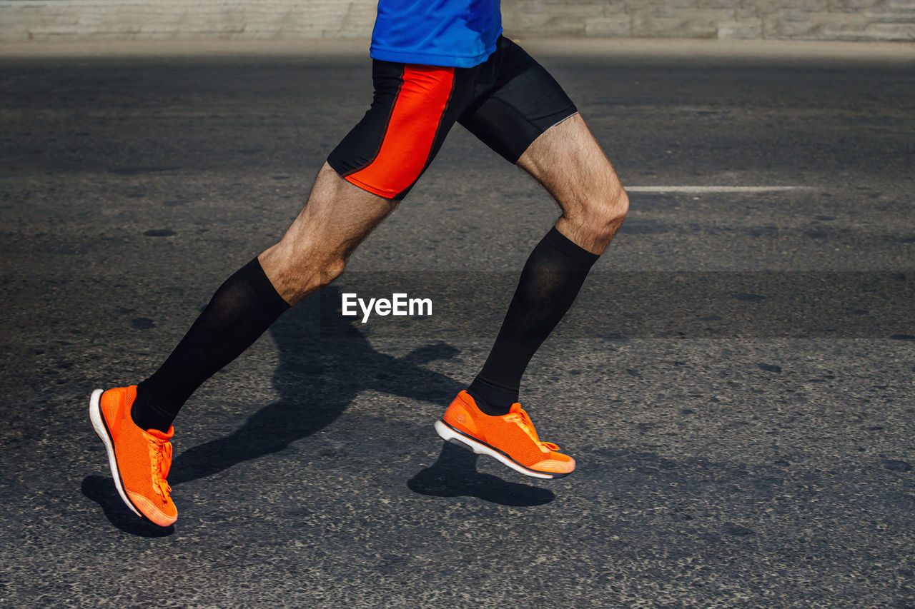 low section of woman jogging on road