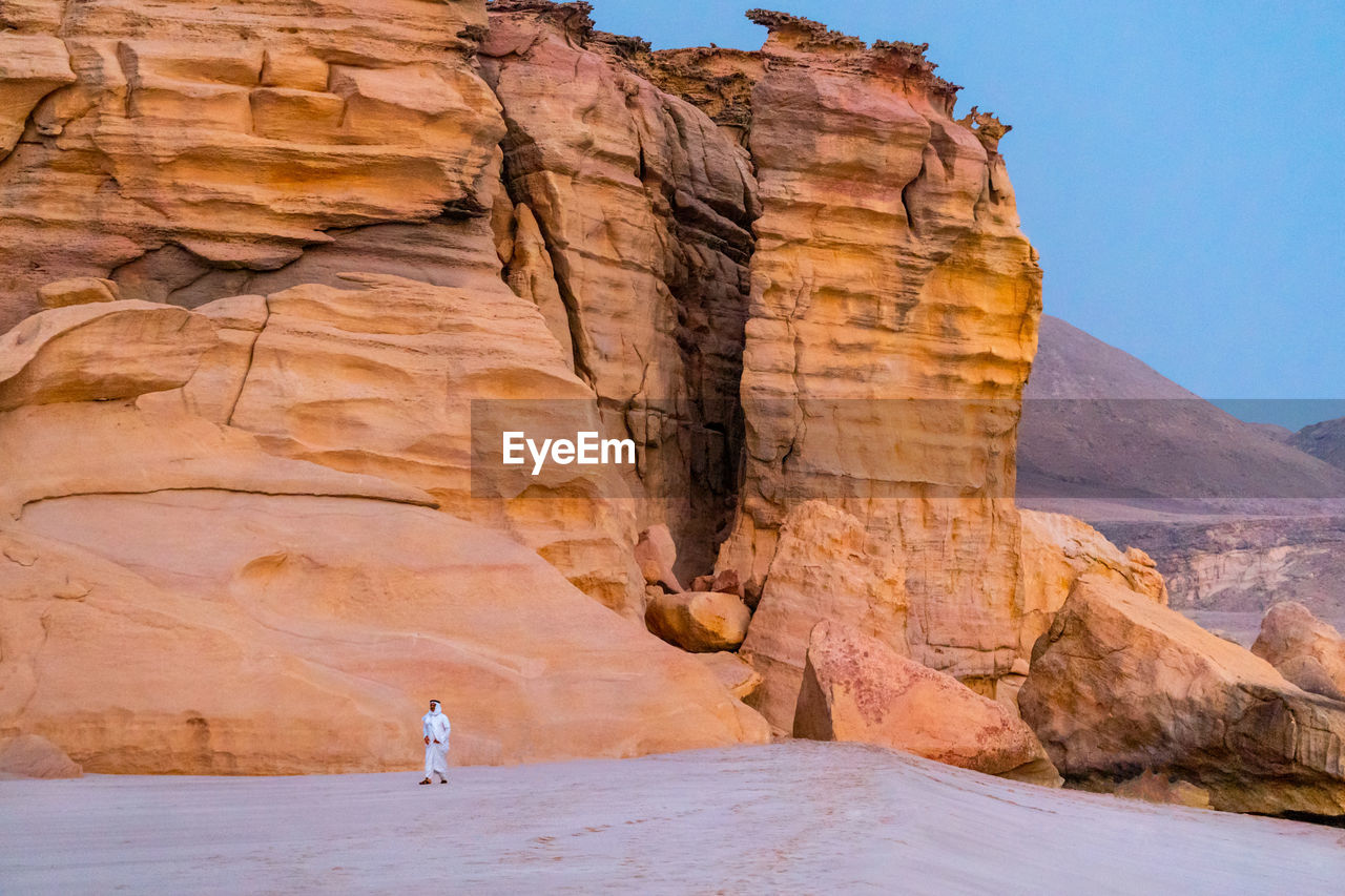 Scenic view of rock formations with man