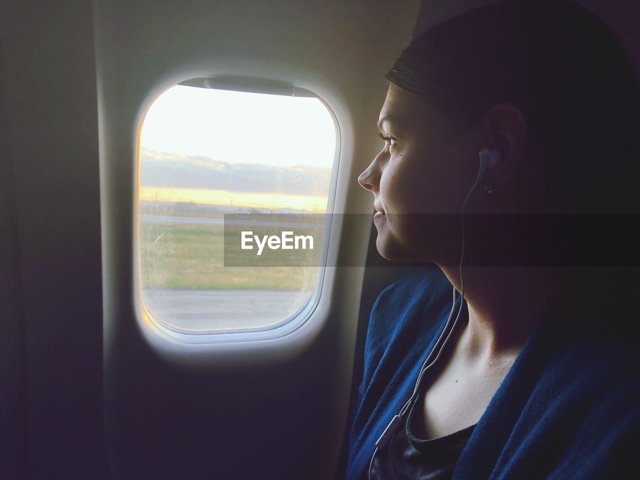 PORTRAIT OF YOUNG WOMAN LOOKING THROUGH WINDOW