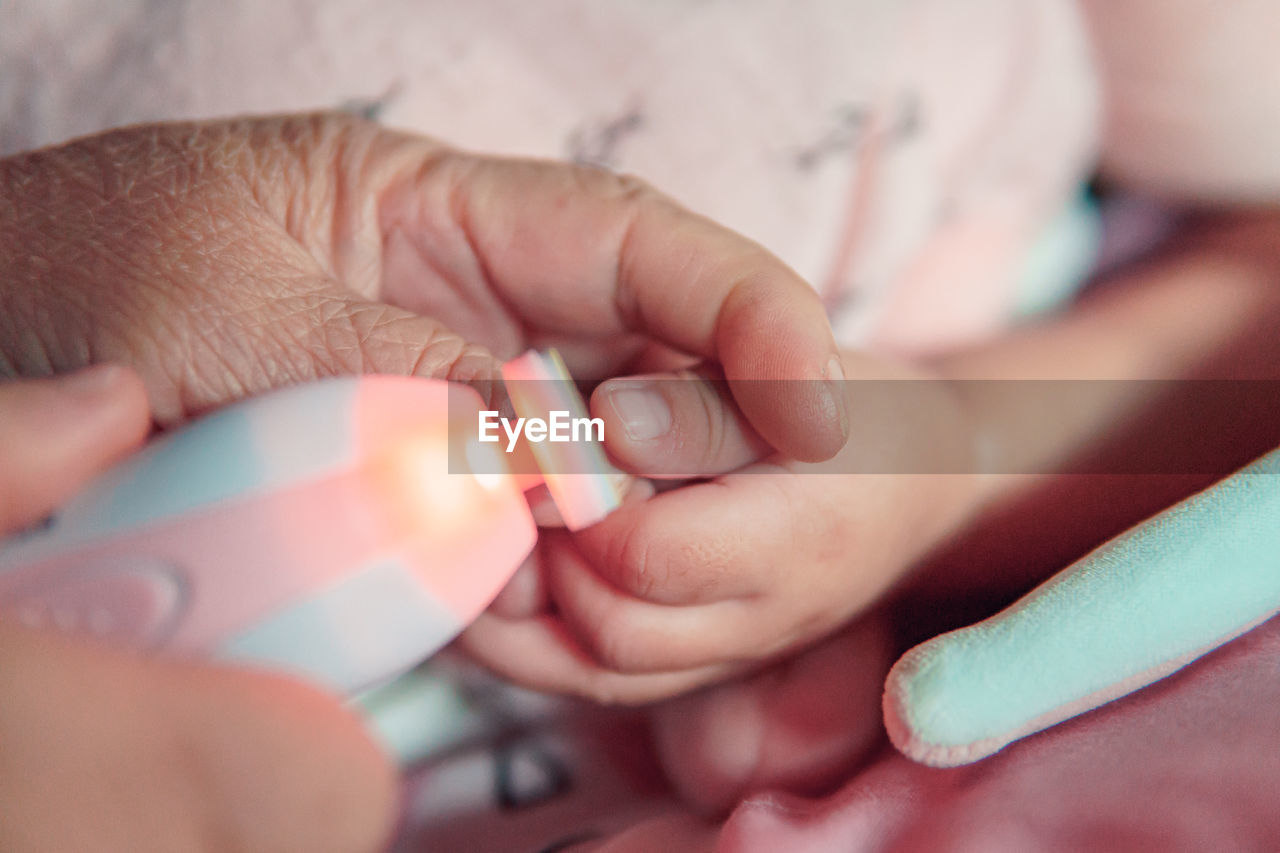 CLOSE-UP OF BABY HAND HOLDING HANDS