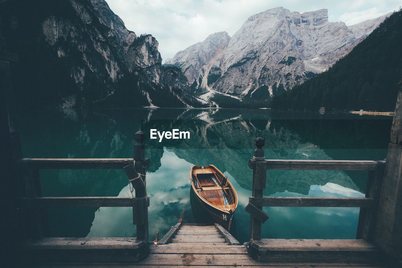 Empty wooden boat on lake with water reflection