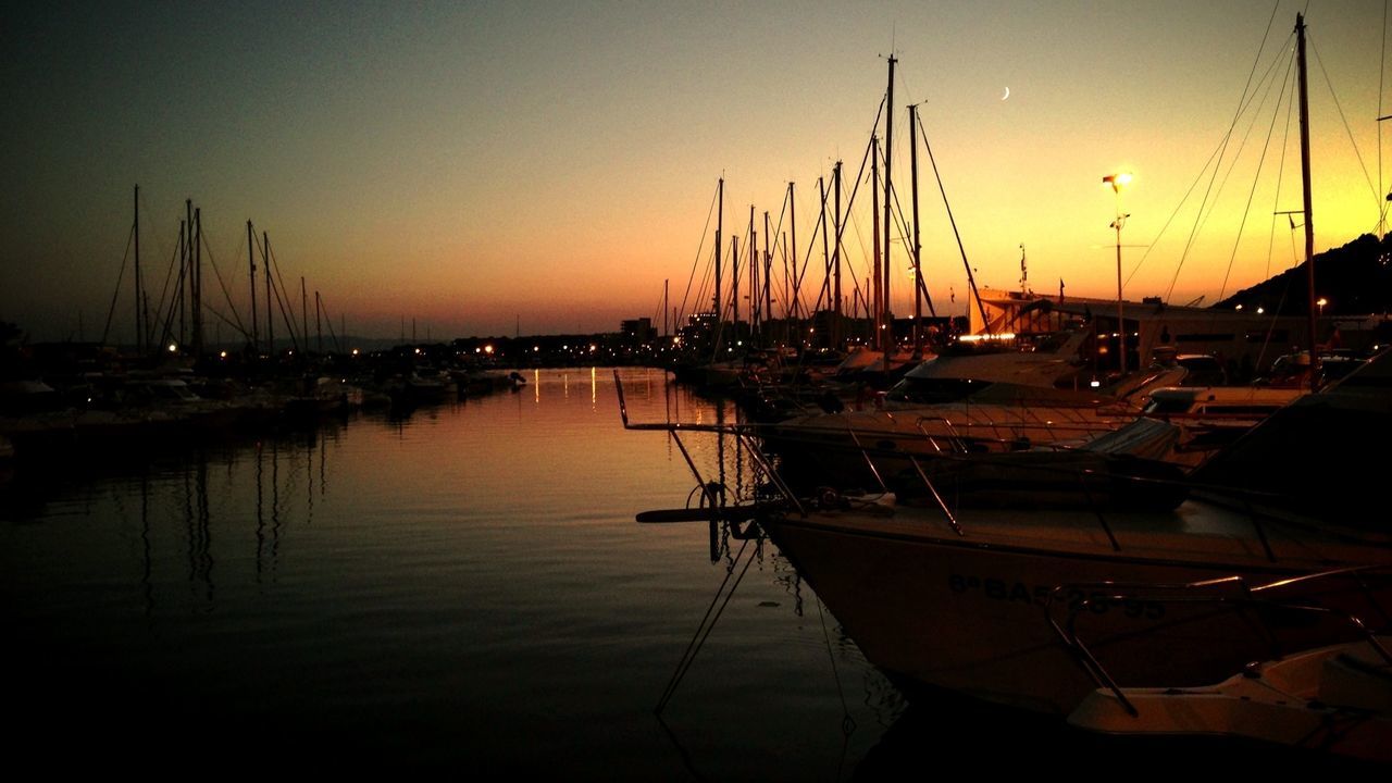 Boats moored in sea during sunset
