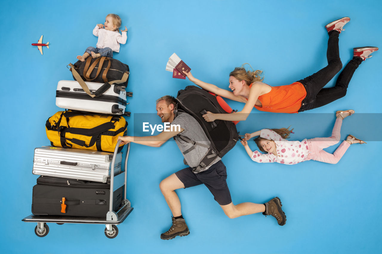 Family with luggage trolley hurrying for departure
