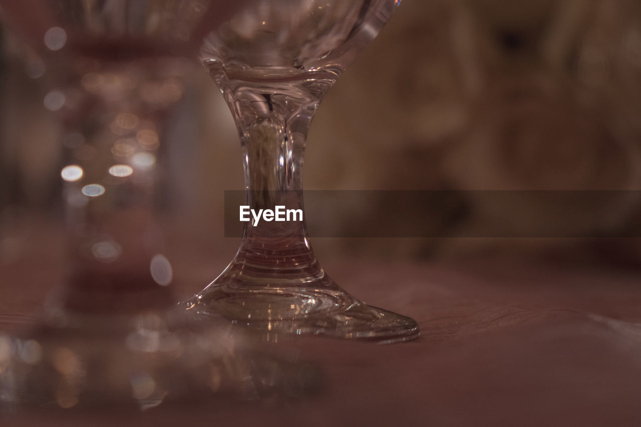 CLOSE-UP OF EMPTY GLASS WITH TABLE