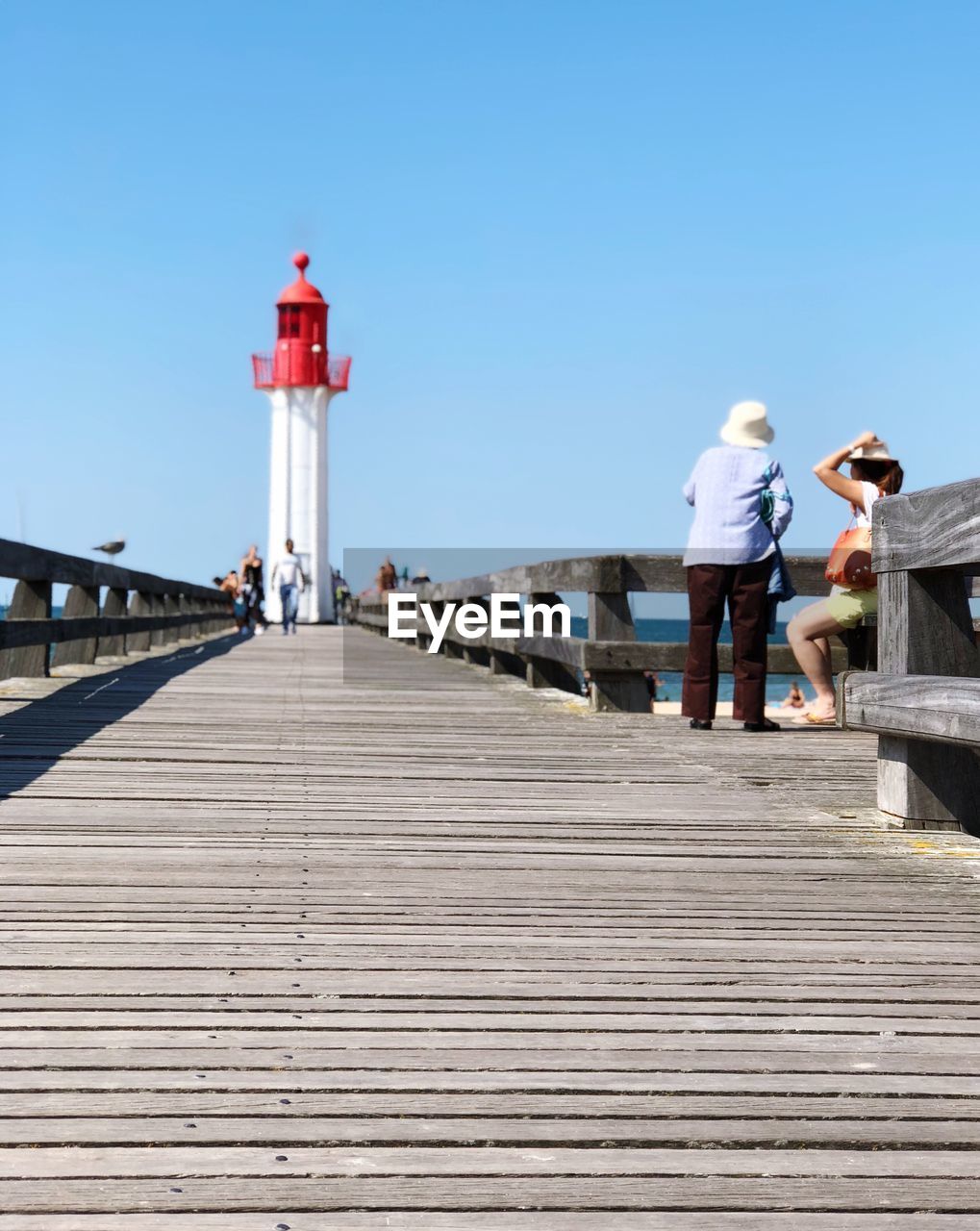 REAR VIEW OF PEOPLE ON PIER