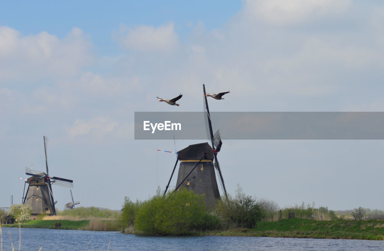 windmill, wind power, renewable energy, wind turbine, turbine, alternative energy, environmental conservation, mill, power generation, sky, nature, environment, traditional windmill, water, wind, day, no people, architecture, machine, cloud, lake, built structure, outdoors, wind farm, technology