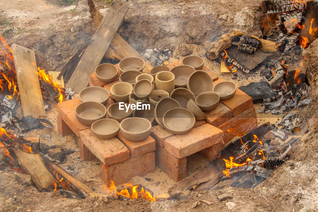 Various ceramic vessels about to be cooked over a campfire