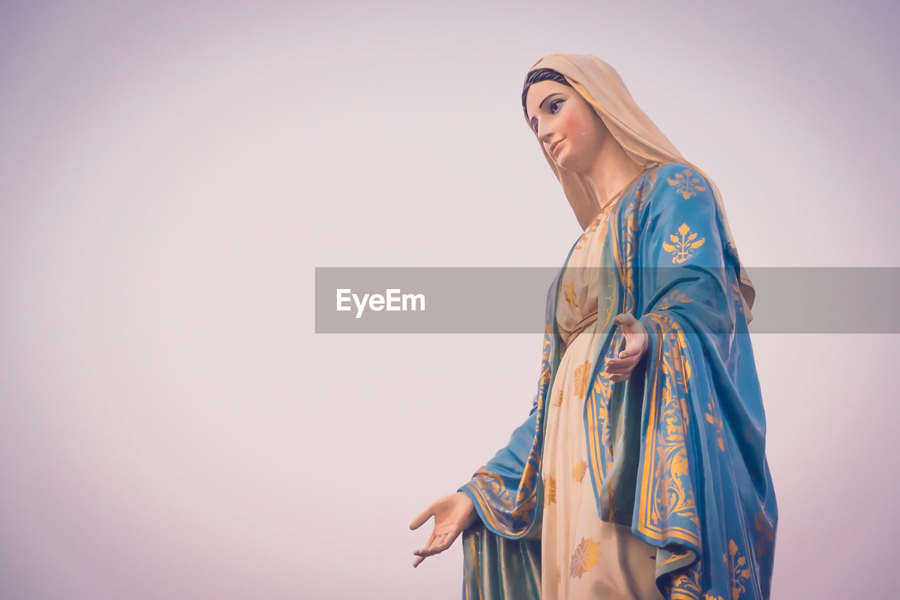 Low angle view of virgin mary statue against clear sky