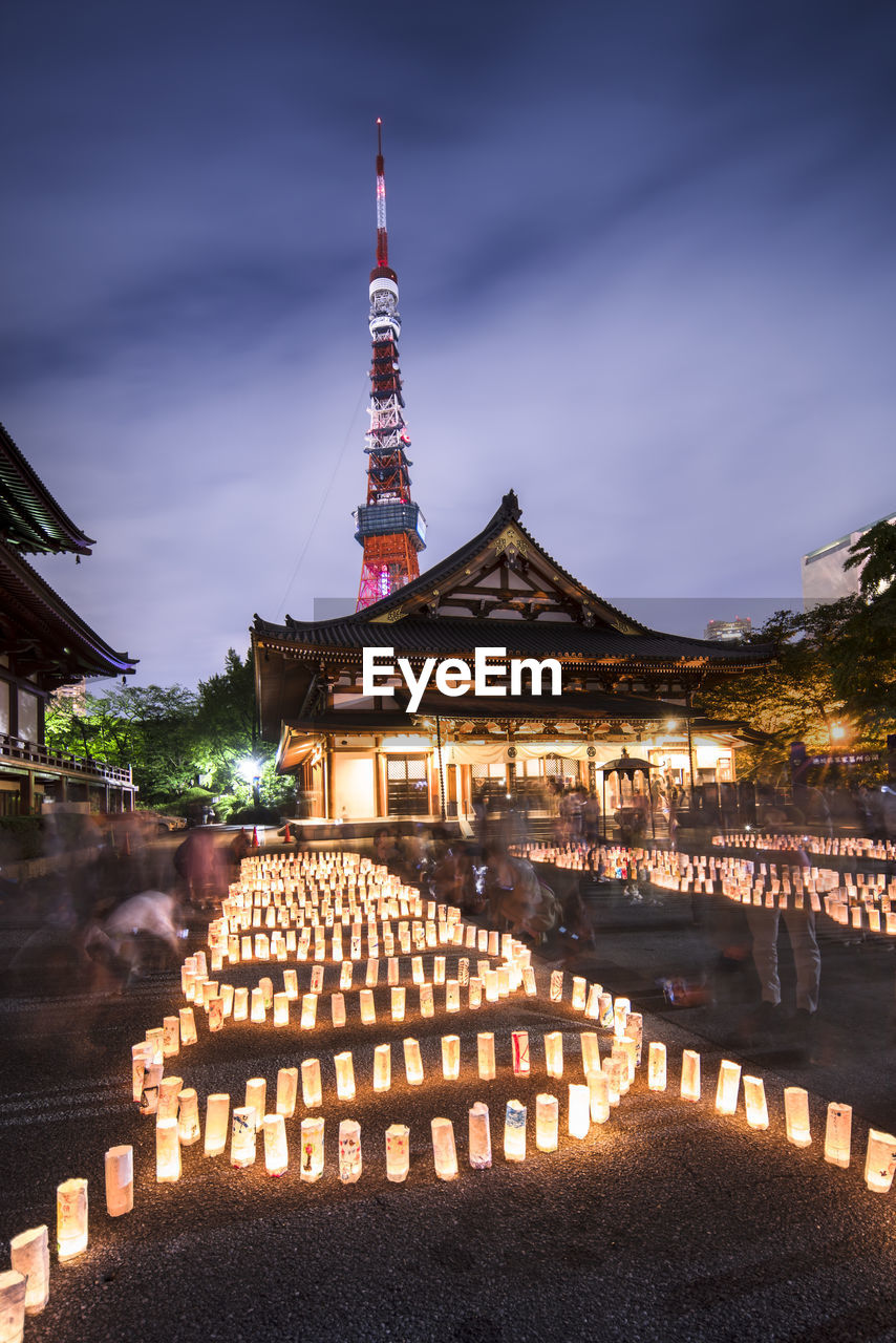 Handmade japanese washi paper lanterns aligned in circles illuminating the zojoji temple.