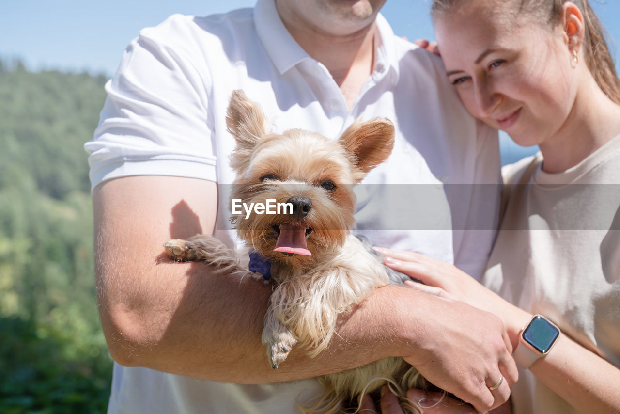 Midsection of man holding dog