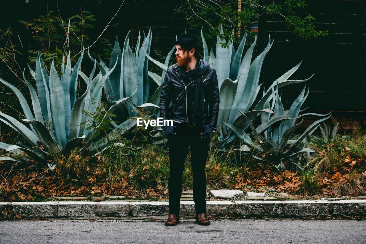 Full length of man standing on sidewalk of park