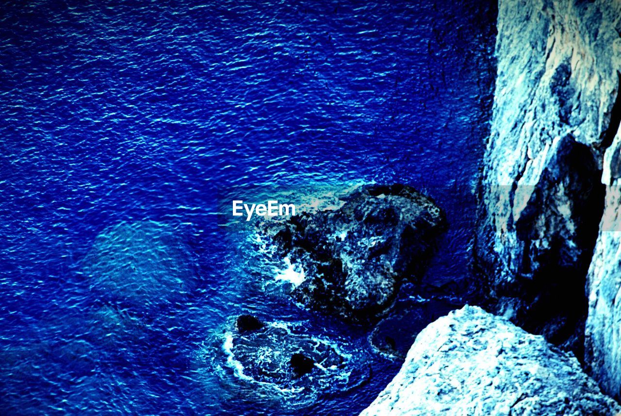 CLOSE-UP OF ROCKS AT SEA SHORE