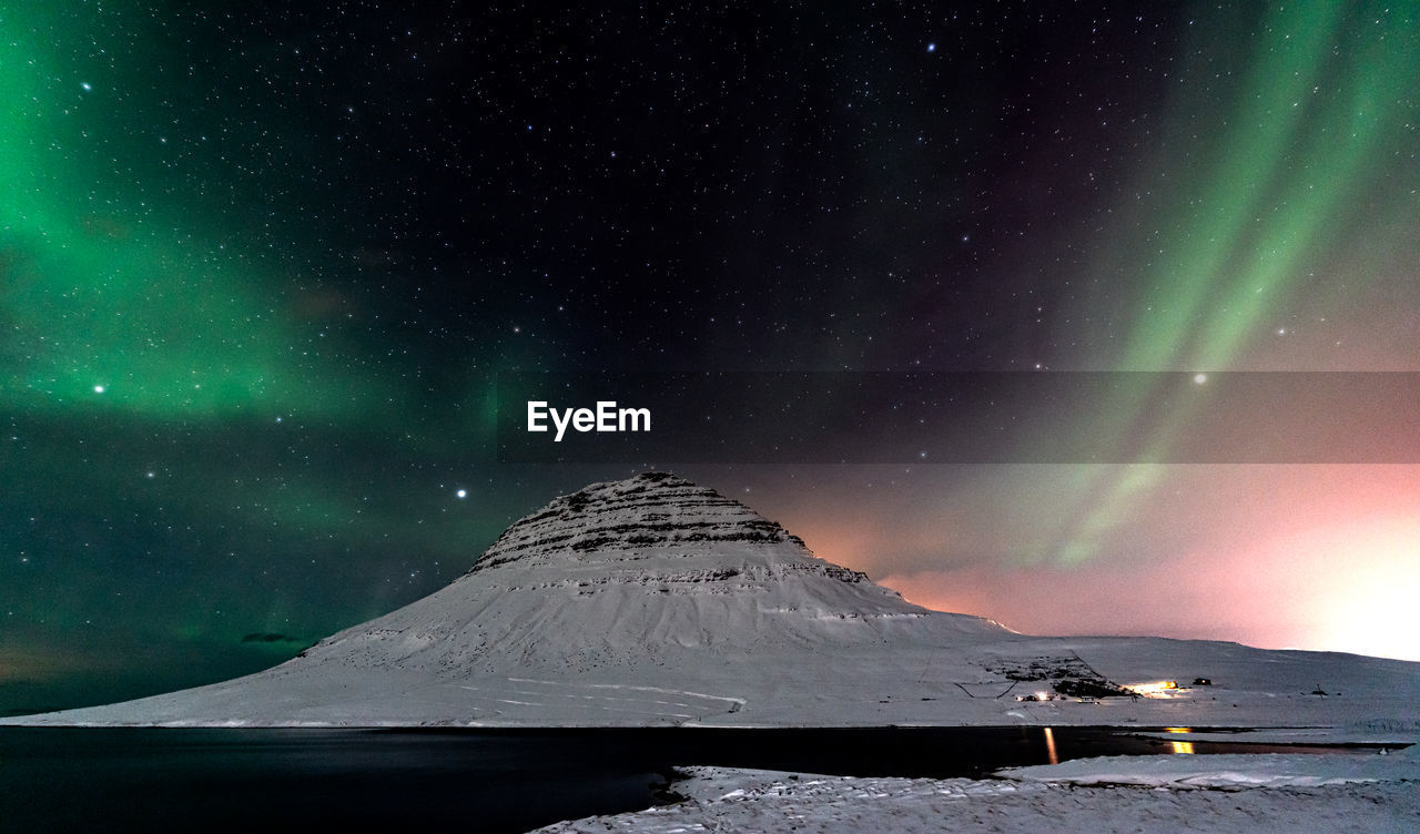 Scenic view of snowcapped mountain against sky at night