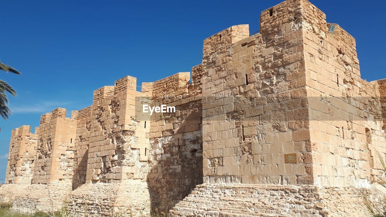 LOW ANGLE VIEW OF OLD RUIN AGAINST BLUE SKY
