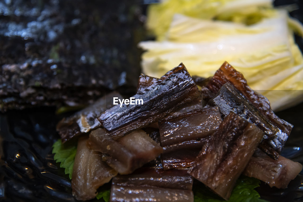 Close-up of food  of  half-dried herring slices, napa cabbage and dried seaweed in plate