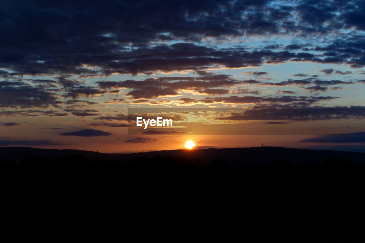 SCENIC VIEW OF SUNSET OVER SILHOUETTE LANDSCAPE