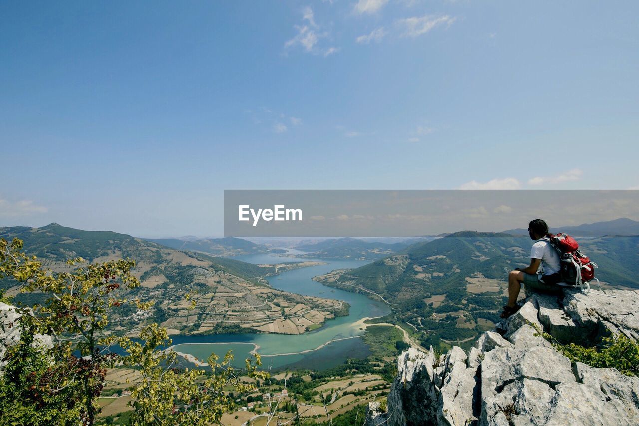 MAN LOOKING AT MOUNTAINS