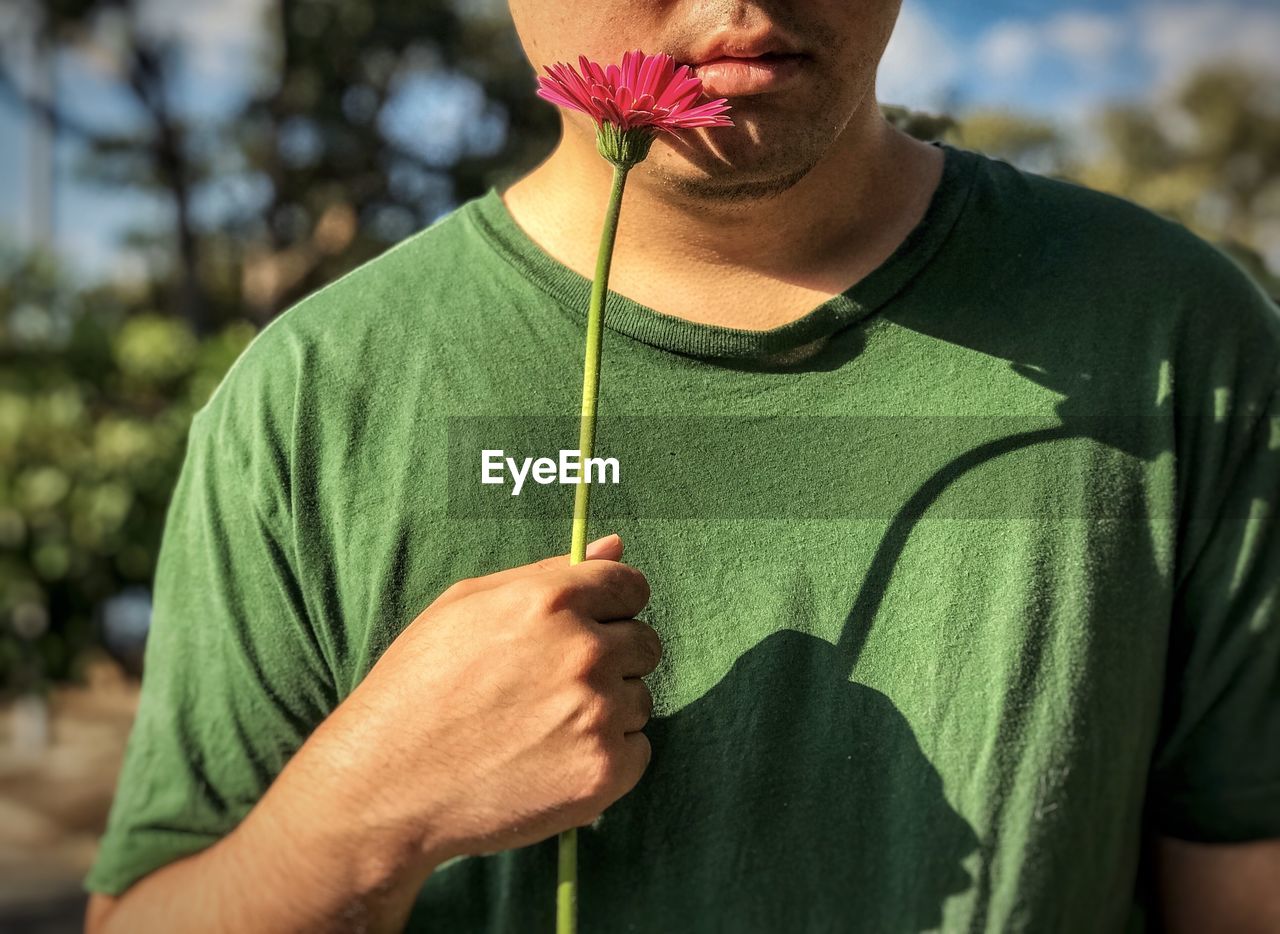 CLOSE-UP OF MAN HOLDING FLOWER