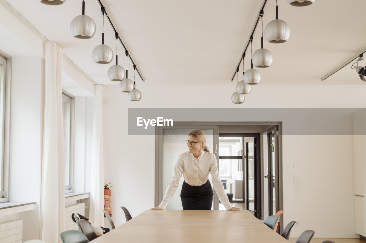 Smiling businesswoman standing in conference room