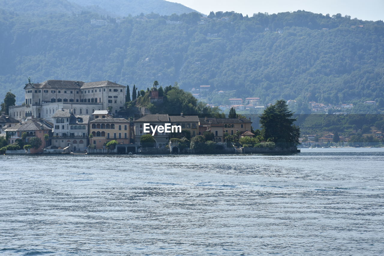 Scenic view of river by mountains against clear sky