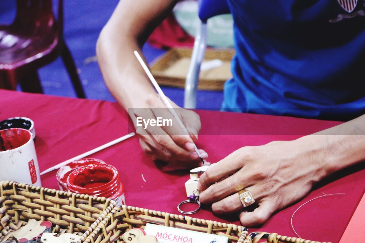 CLOSE-UP OF HANDS PLAYING PIANO ON TABLE