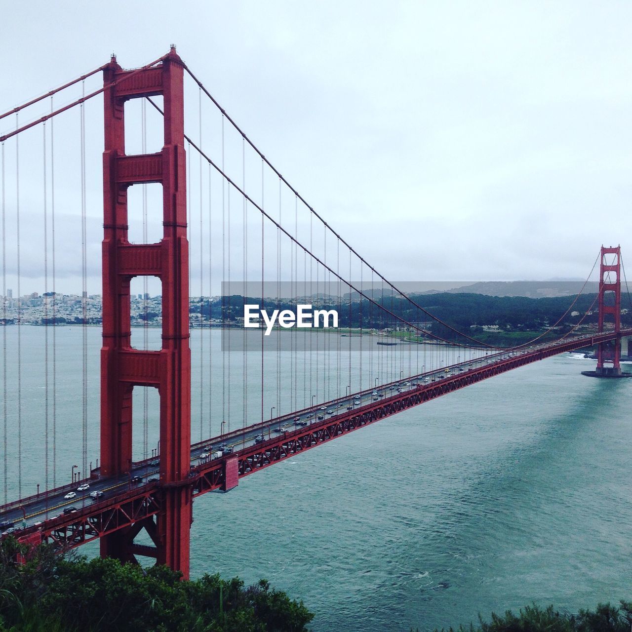 Golden gate bridge over river against sky in city