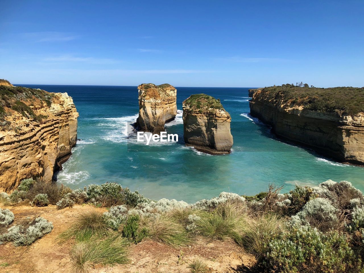 Scenic view of rocks in sea against blue sky