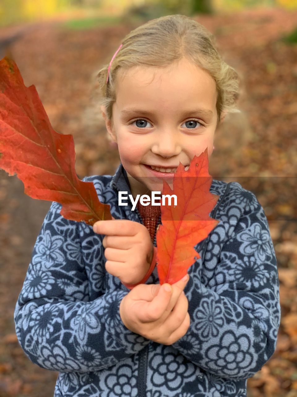 Portrait of happy girl with autumn leaves