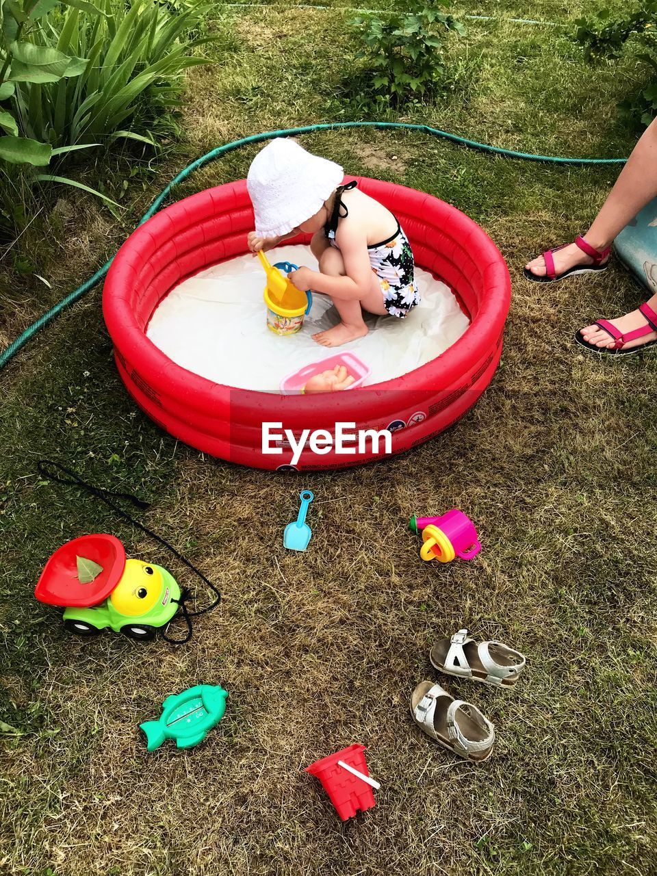 HIGH ANGLE VIEW OF GIRL PLAYING WITH TOY ON LAND