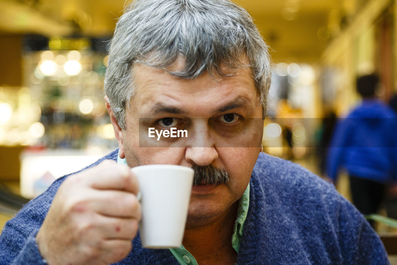 Portrait of man holding coffee cup