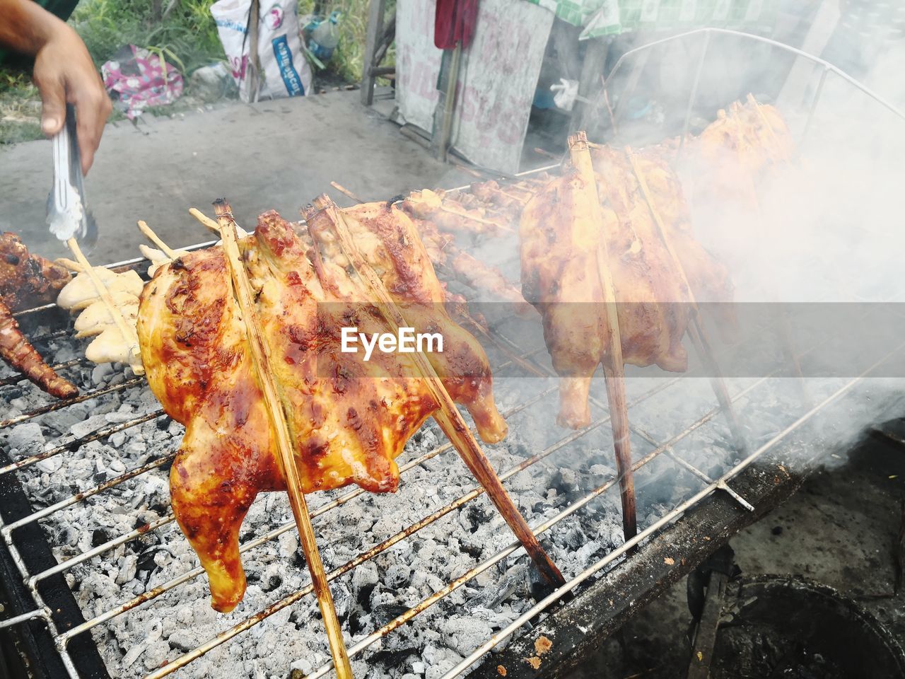 CLOSE-UP OF HANDS ON BARBECUE