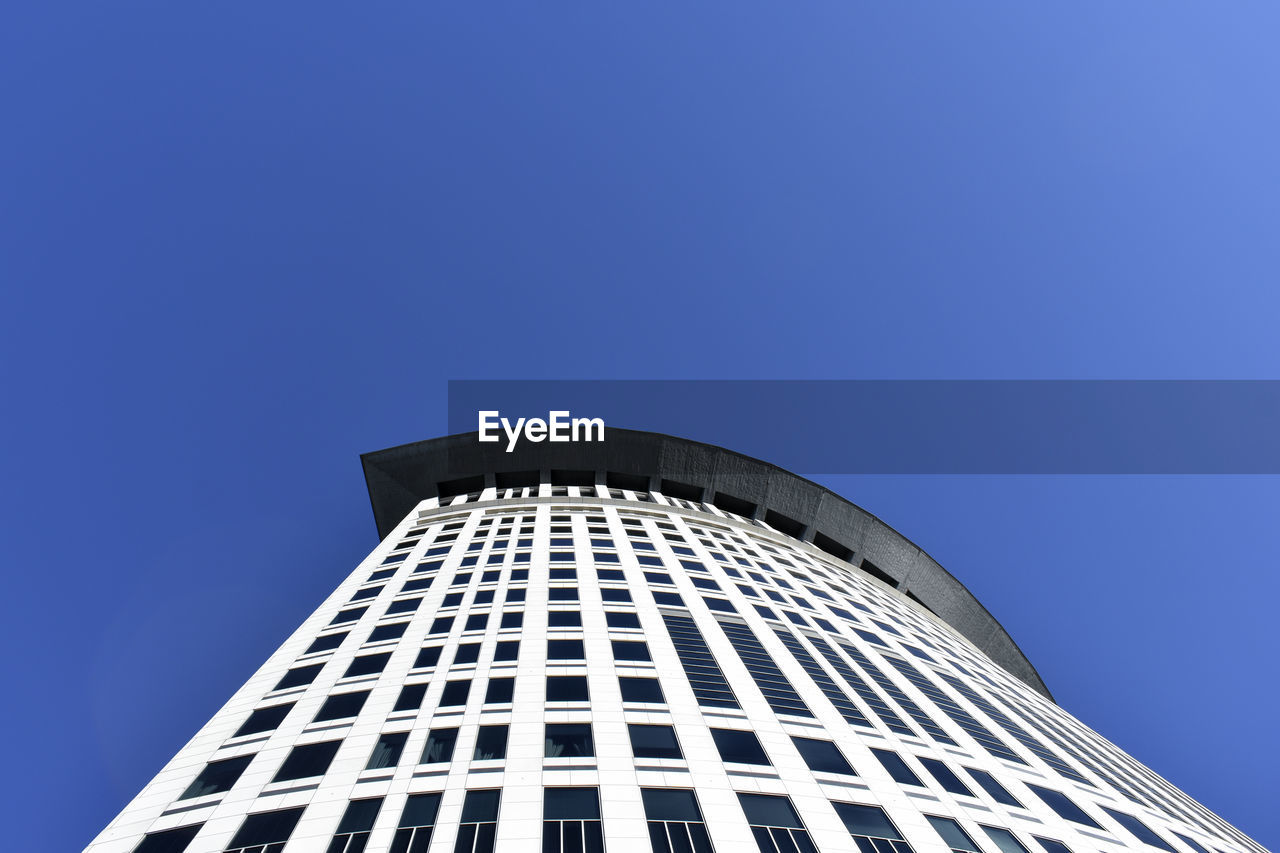 Low angle view of modern building against clear blue sky