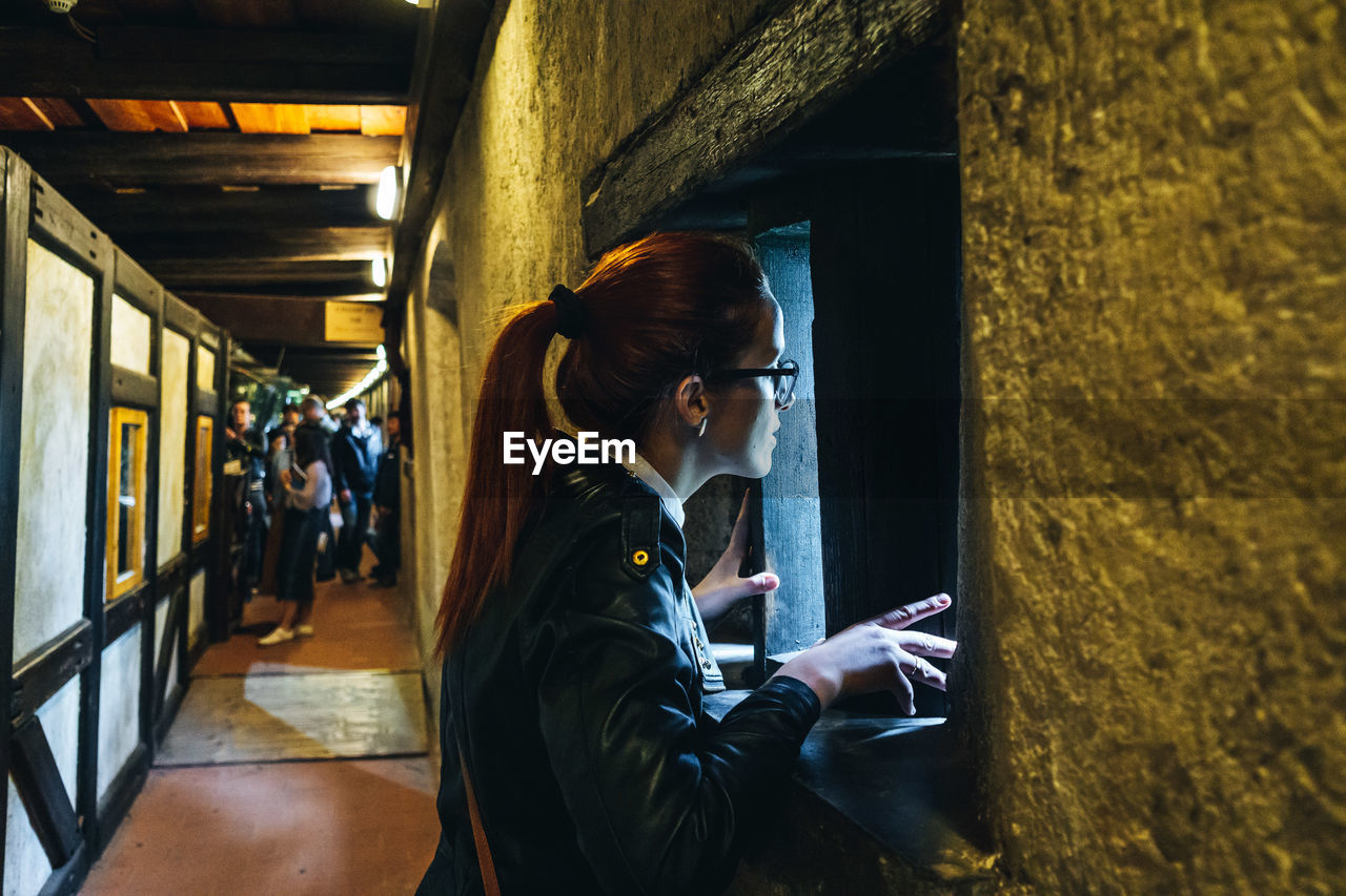 Woman looking through small window in temple