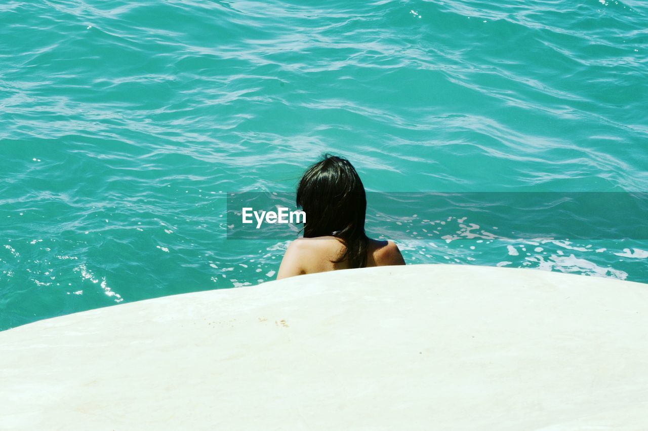 Rear view of woman swimming in sea