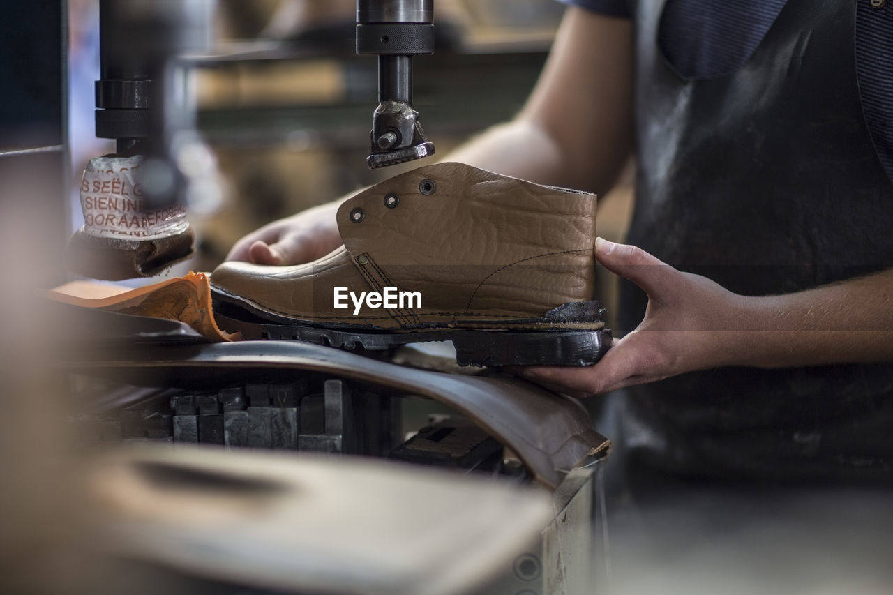 Shoemaker working on shoe in workshop