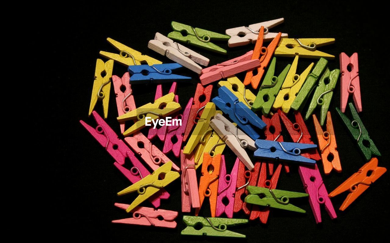 Close-up of colorful clothespins over black background