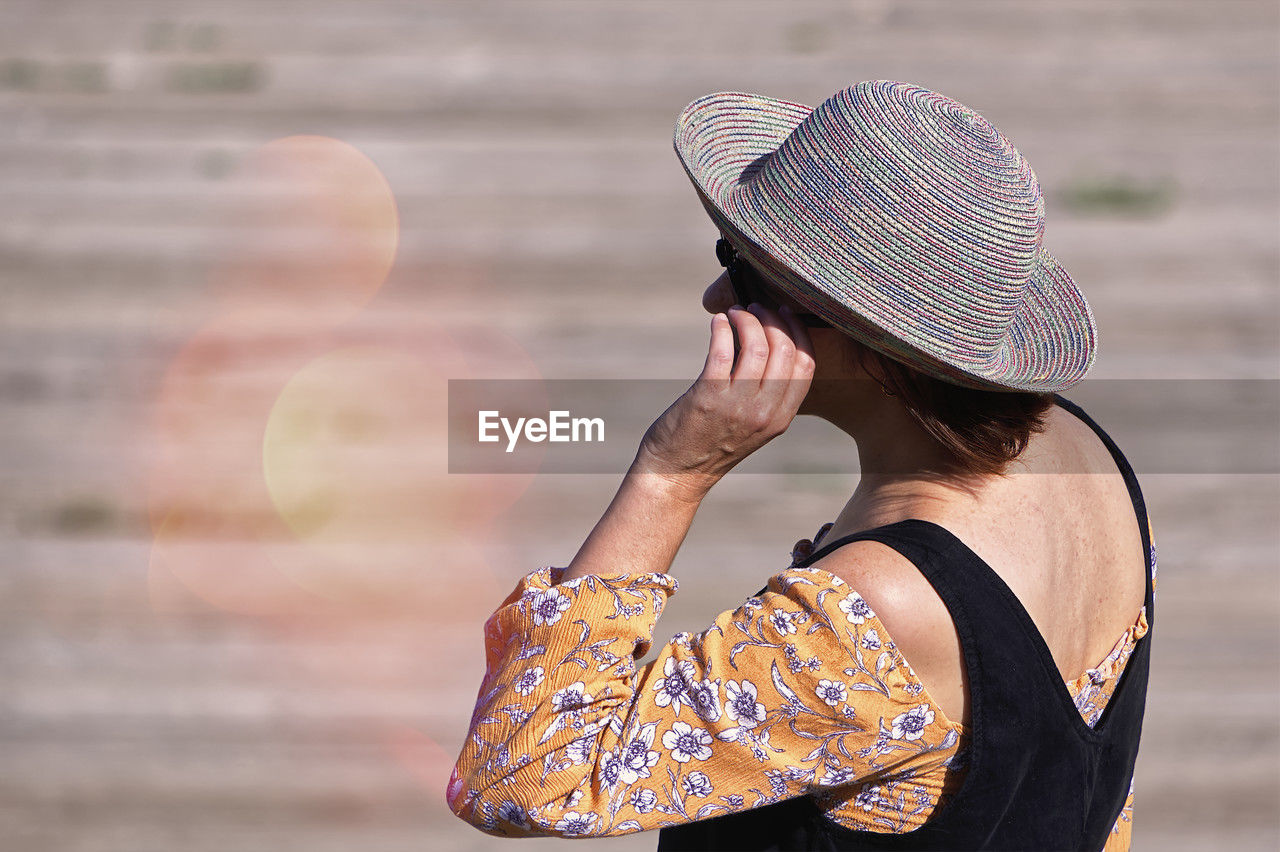 side view of woman wearing hat standing outdoors