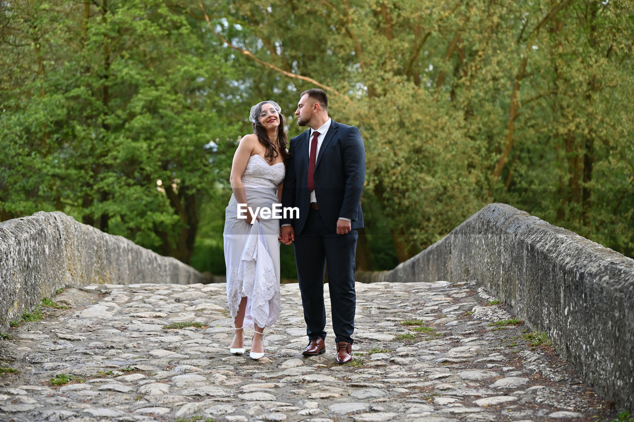 Full length of couple standing on footpath