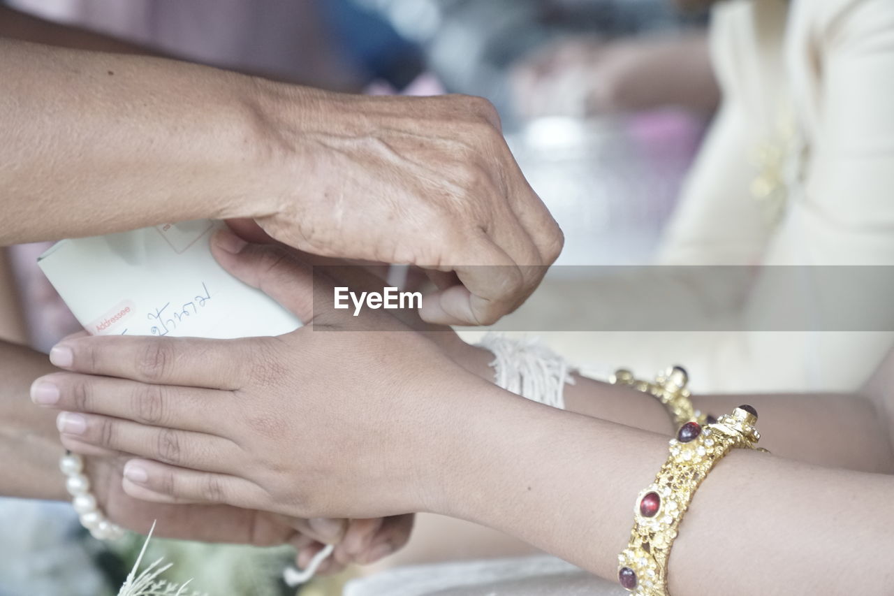 CLOSE-UP OF WOMAN HAND HOLDING HANDS WITH TATTOO