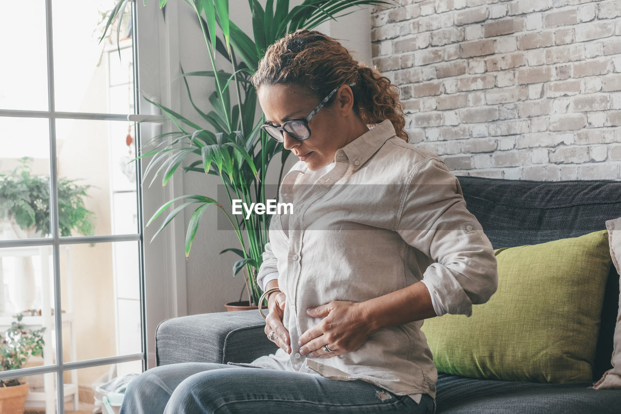 young man using laptop while sitting on sofa at home