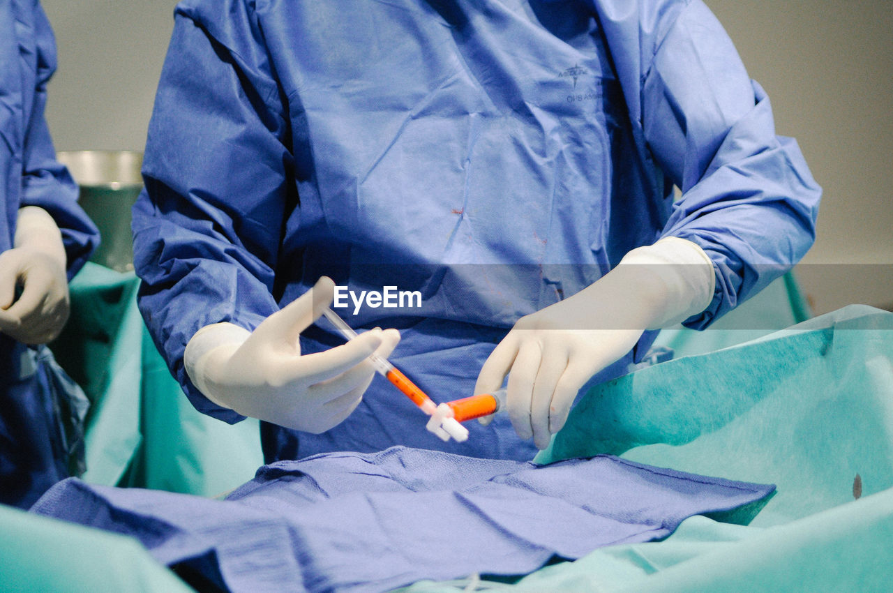 Midsection of surgeons in operating room at hospital