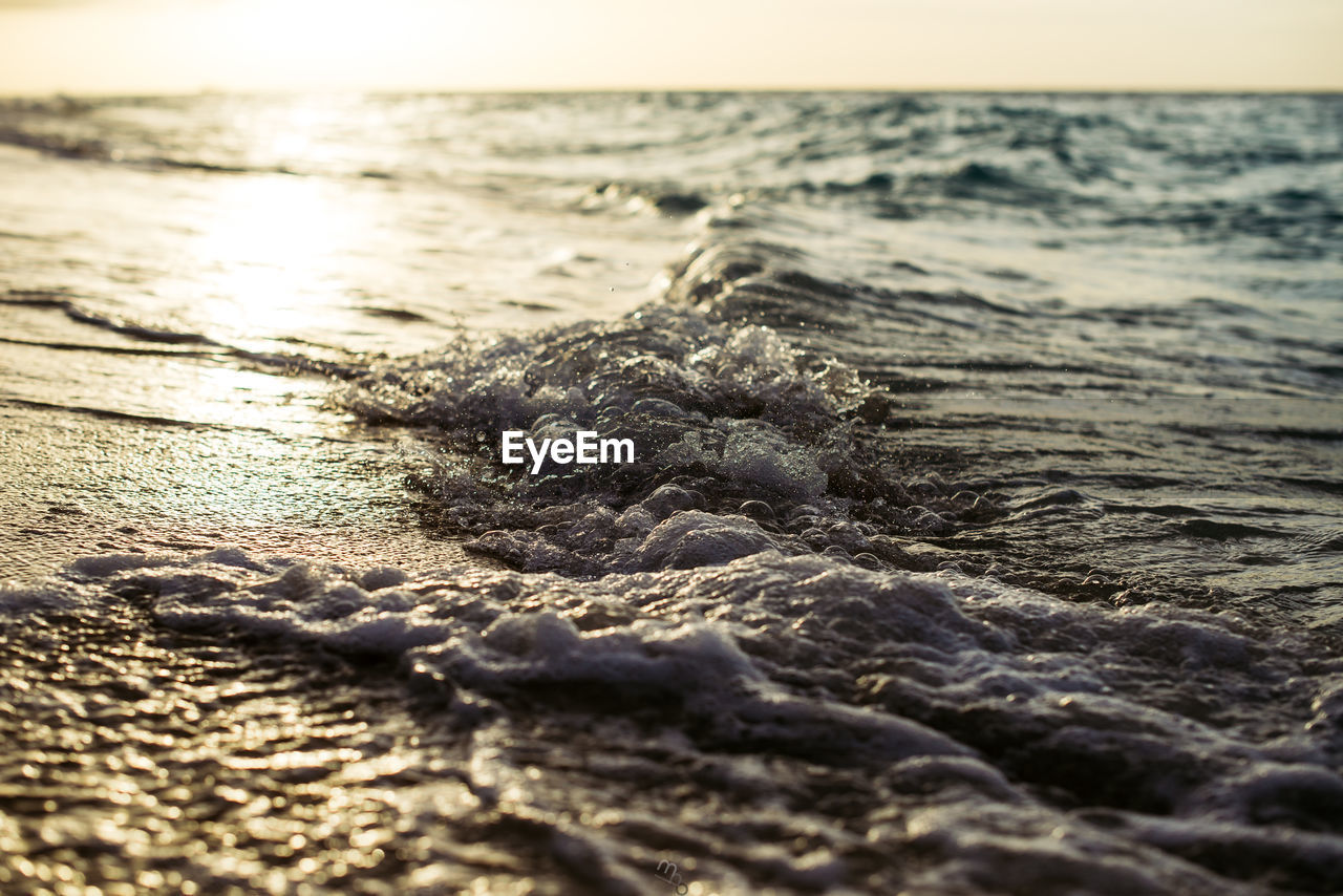 CLOSE-UP OF WAVE ON SHORE