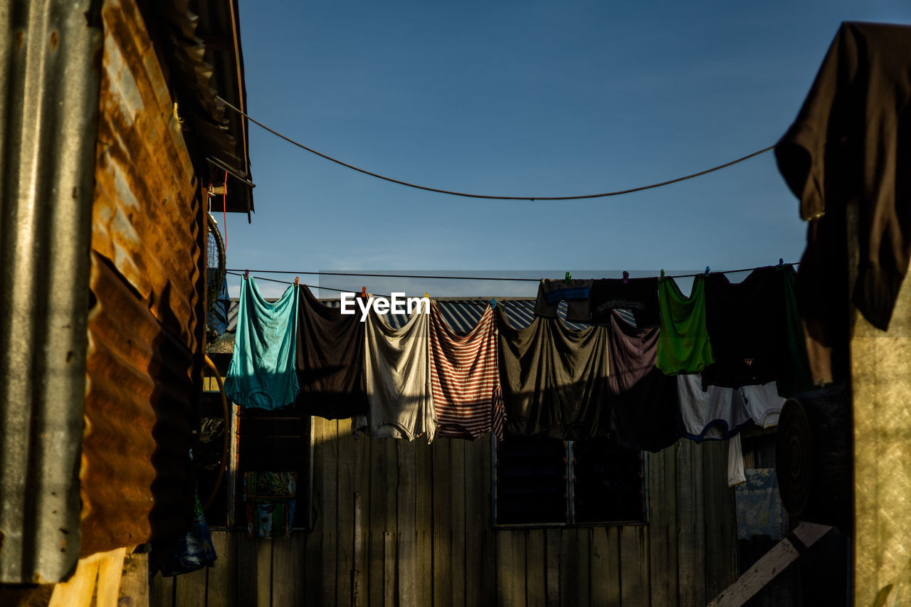 Low angle view of clothes drying on rope against building
