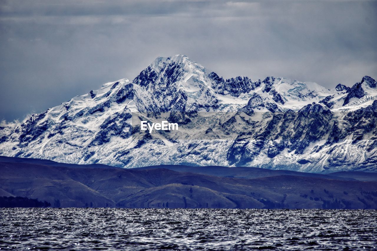 scenic view of snowcapped mountains against cloudy sky